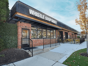 A Whistle Stop Diner with a black awning and brick building at Eton Square Apartments and Townhomes, Michigan